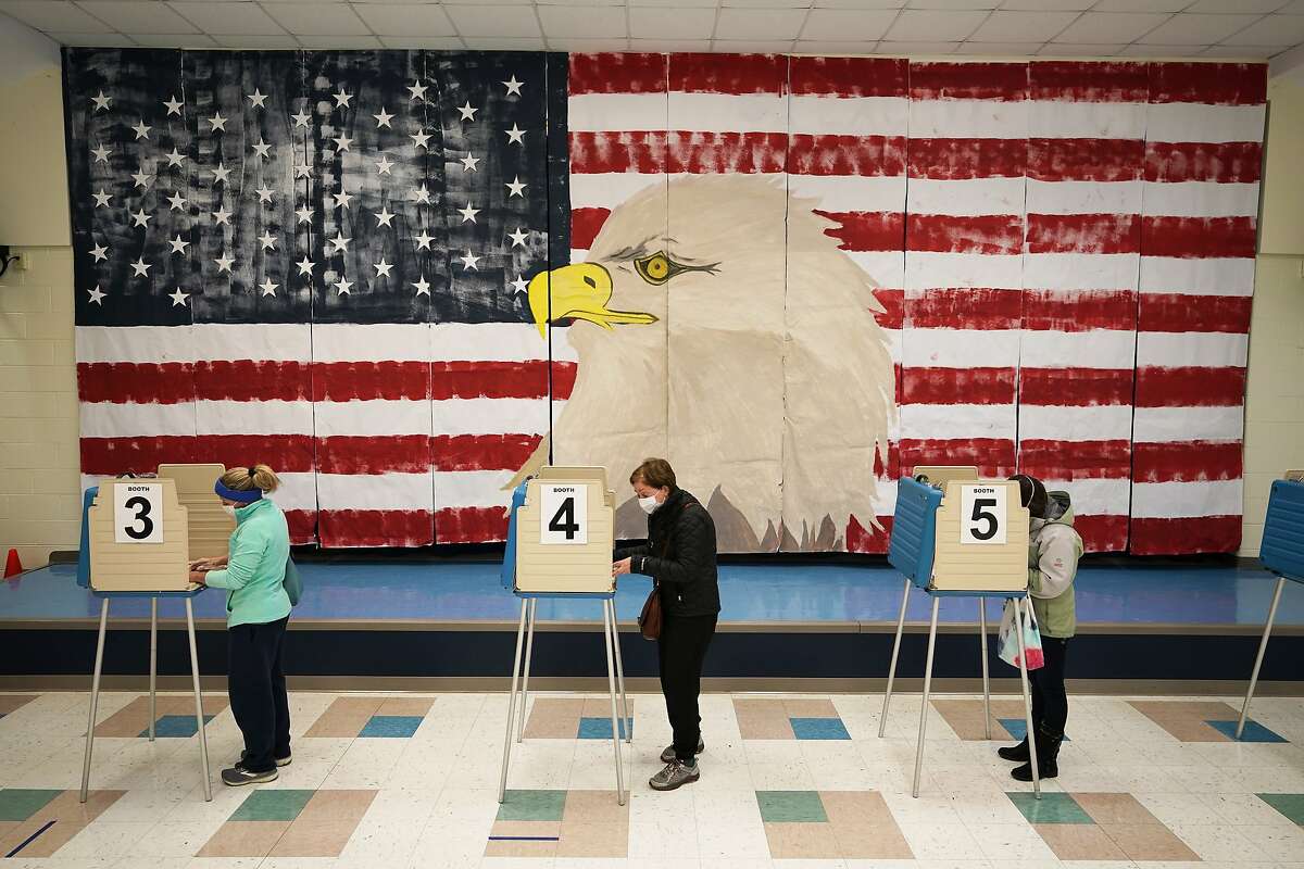 Voters cast their ballots under a giant mural at Robious Elementary school on Election Day, in Midlothian, Va., Tuesday Nov. 3, 2020. Poll workers said that traffic was slow due to all the early voting in the precinct.