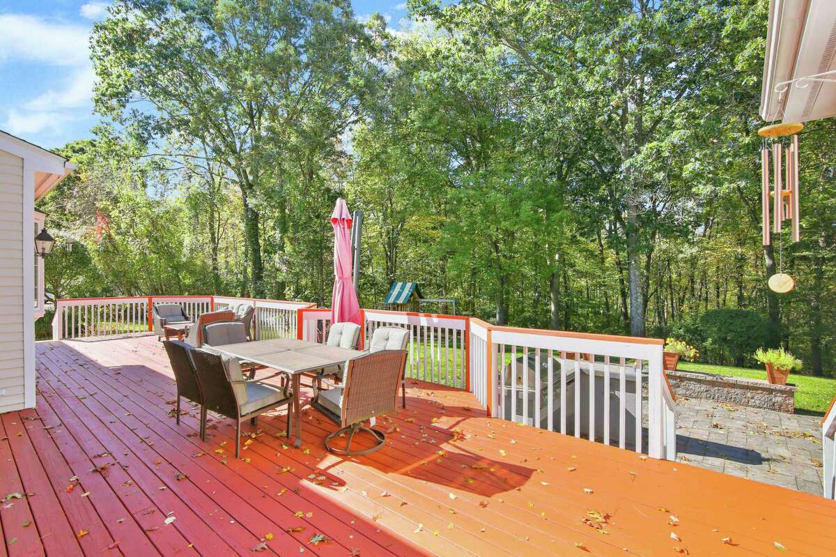 The sizable raised wood deck looks over this home's 3.49-acre level property. This house is also close to one of Connecticut's largest Christmas tree nurseries, meaning if the next owners purchase now, they could be settled into their new home by Christmas and won't have far to go to select the perfect holiday tree. The manicured lawn and attractive landscaping serves as an enticing entrance to the property. Turn into the wide driveway at the mailbox, the post of which is decorated with hand-painted dogwood blossoms. From there a long paving stone path leads to the entrance where there is a decorative transom and sidelights. The front door opens into the two-story foyer, which has marble flooring. Inside, this meticulously maintained house offers an open floor plan with an abundance of natural light. According to the listing agent,