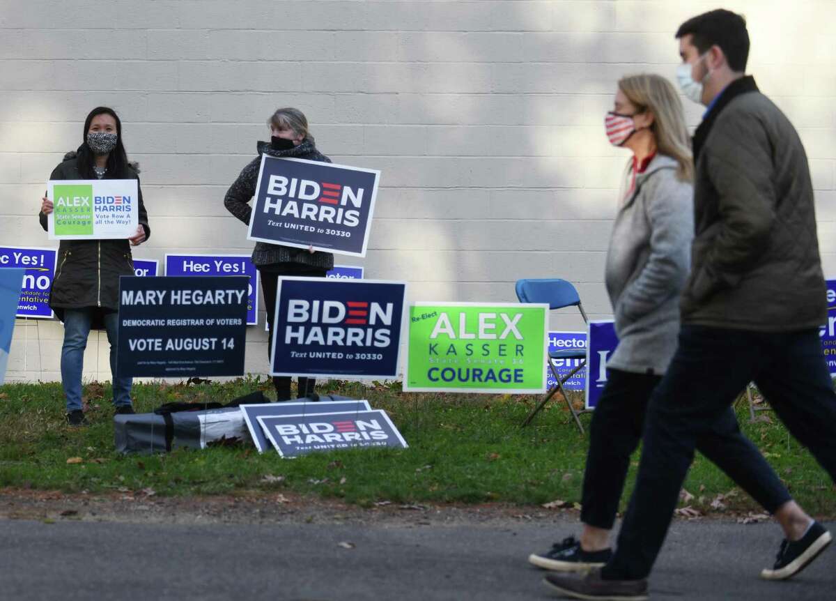 Cos Cob residents Janet McMahon, left, and Sheila Phelan hold signs supporting Democratic candidates on Election Day 2020 outside the District 8 polling center at Central Middle School in Greenwich, Conn. Tuesday, Nov. 3, 2020. Connecticut residents cast their votes Tuesday in the Presidential Election between incumbent Republican Donald Trump and Democratic challenger Joe Biden.