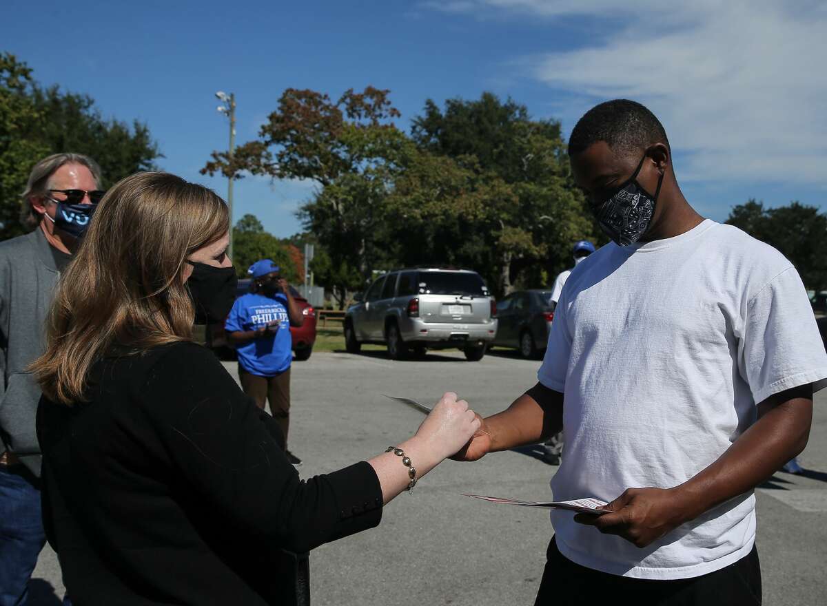 US Congresswoman Lizzie Fletcher greets voter Gregory Coleman Jr. Tuesday, Nov. 3, 2020, at Bayland Community Center in Houston. Fletcher is seeking for reelection.
