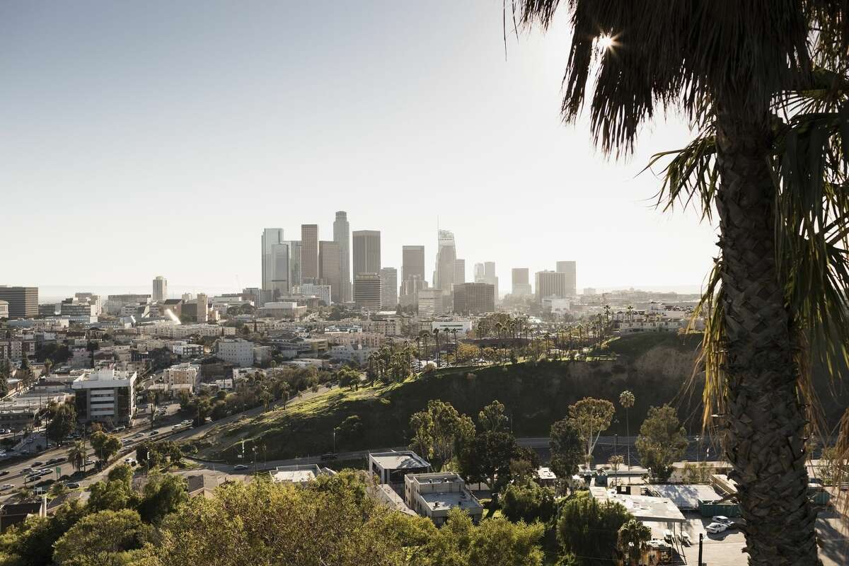 The Los Angeles skyline rises in the distance.