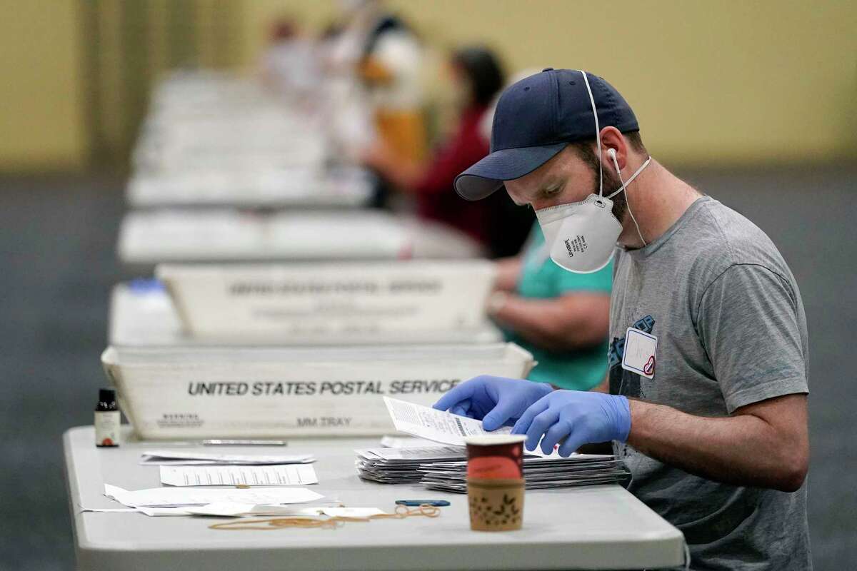 Workers prepare mail-in ballots for counting, Wednesday, Nov. 4, 2020, at the convention center in Lancaster, Pa. A flood of mail ballots across the country added drama to an already tense presidential contest, columnist Gilbert Garcia says.