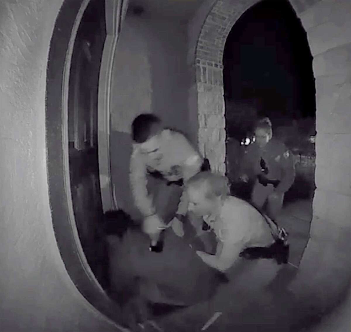 A screen grab from a home surveillance video shows Schertz police officers tasing and forcibly restraining Zekee Rayford, 18, on the front steps of his home.