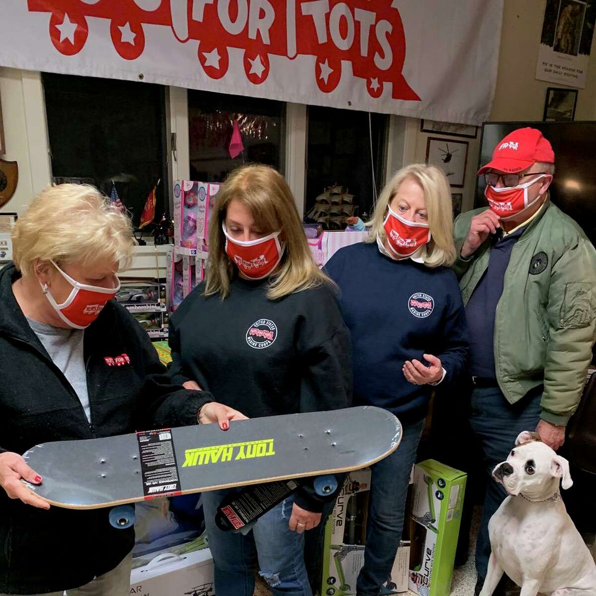 Toys for Tots coordinators (from left) Shirley Wilken and Pam Petti along with campaign program co-chairs Carole Watson and Henry Norley check out a skateboard with advice from United States Marine Corp Canine 1st Sgt. Oliver Norley during a previous Toys for Tots campaign program, which has just started for this year, 2020. The Toys for Tots program, which serves disadvantaged children at Christmas time, distributes more than 30,000 unwrapped toys and sports items every year with the help of local churches and youth organizations. It is operated by the Marine Veterans of Fairfield County. Norley is also a longtime member of the Marine organization and a coordinator of the Toys for Tots campaign program.