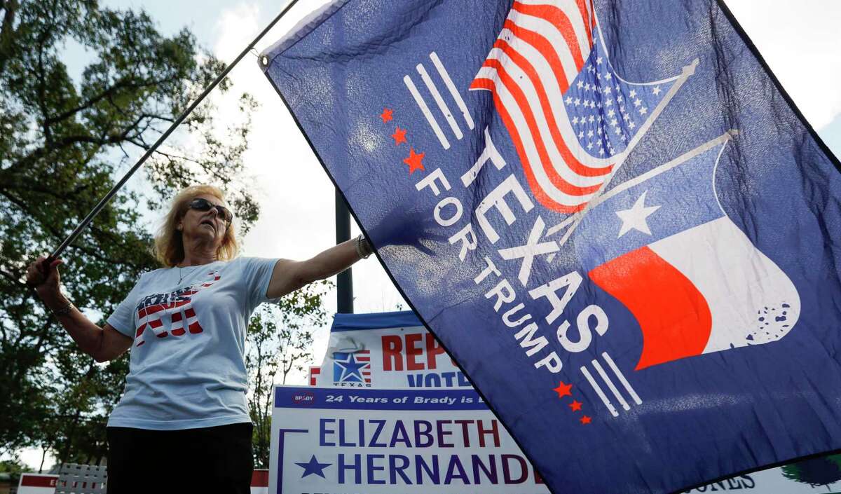 Montgomery County Republican Party Precinct 98 Chairman Neda Henery waves a flag showing support for President Trump in front of the early voting location at the South Montgomery County Community Center, Wednesday, Oct. 21, 2020, in The Woodlands.