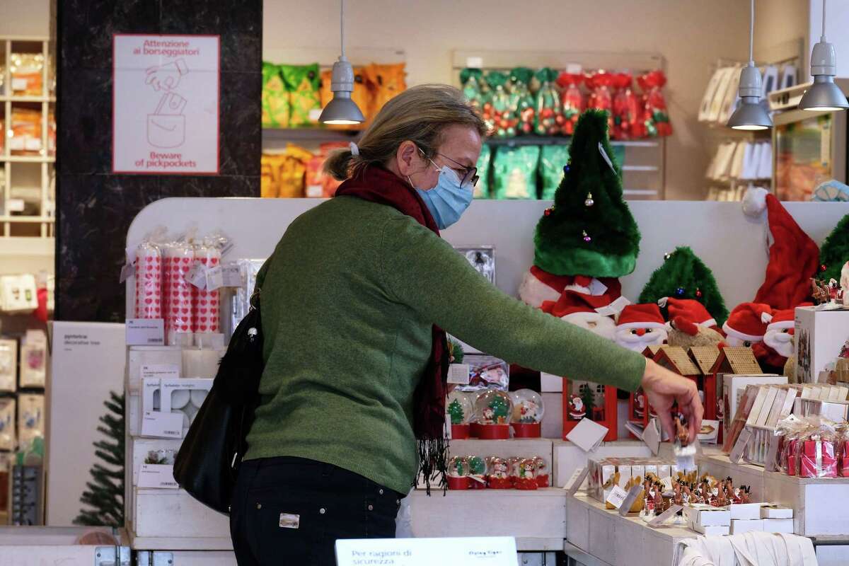 A woman wearing a protective mask looks for a gift in a store in central Rome on Nov. 5, 2020.