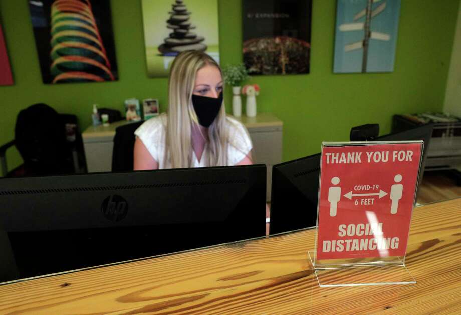 A sign showing the requirement to socially distance in the office sits on the desk of Taylor Mills, administrative assistant at the Armanino offices at Bishop Ranch in San Ramon, Calif., on Tuesday, June 16, 2020. The massive Bishop Ranch office and retail complex in San Ramon has started reopening. Armanino, an accounting firm that is planning to welcome back more office workers, Fieldwork, a brewpub doing outdoor dining, and Heller Jewelers, which recently opened in the center are businesses that are seeing strong foot traffic. Photo: Carlos Avila Gonzalez / The Chronicle / ©San Francisco Chronicle/Carlos Avila Gonzalez