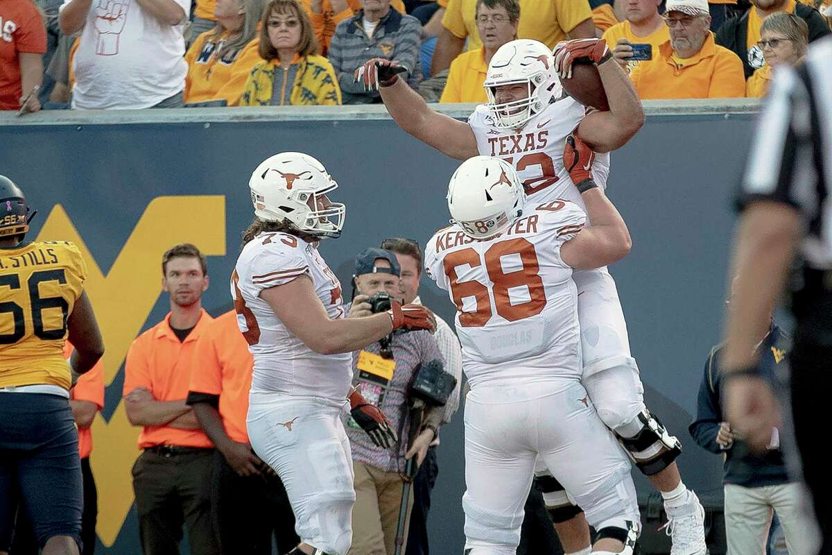 FILE - In this Oct. 5, 2019, file photo, Texas offensive lineman Samuel Cosmi (52) celebrates a touchdown against West Virginia during an NCAA college football game in Morgantown, W. Va. Cosmi lived every offensive lineman’s dream when he caught a lateral from Sam Ehlinger and rumbled 12 yards for a touchdown in a 42-31 win over West Virginia. (Nick Wagner/Austin American-Statesman via AP, File)