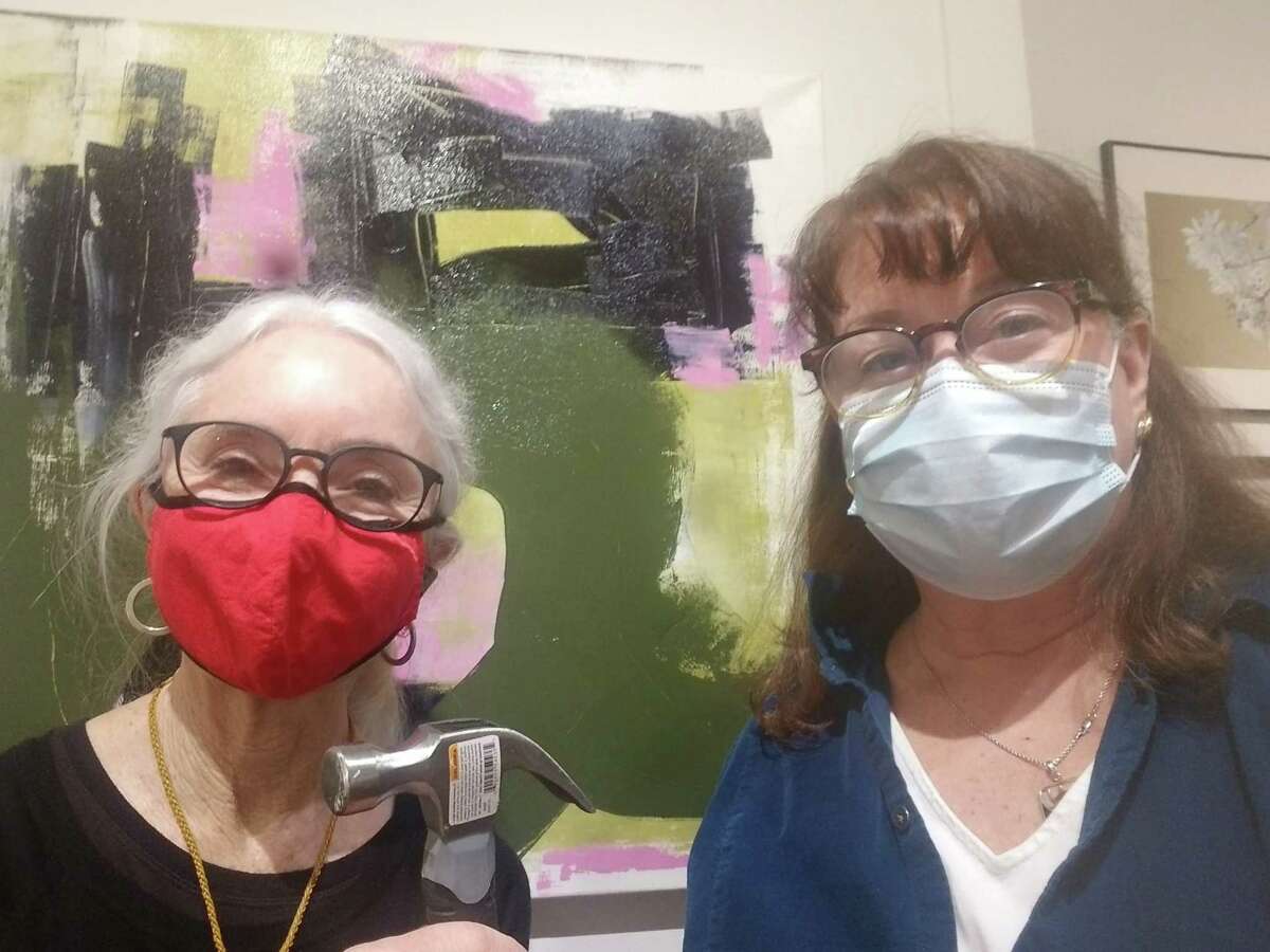 Ridgefield Guild of Artists' co-creative directors Erin Nazarro and Cindi Mullins stop for a moment during the design and hanging of the in-gallery and online holiday art show titled: