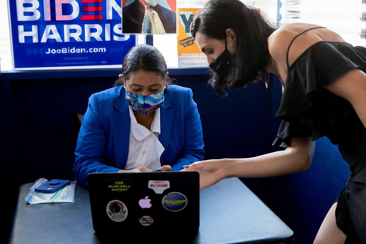 Mayor London Breed (left) gets some help from Jupiter Peraza during an election day phone bank for Democratic candidates outside Manny’s cafe in the Mission.