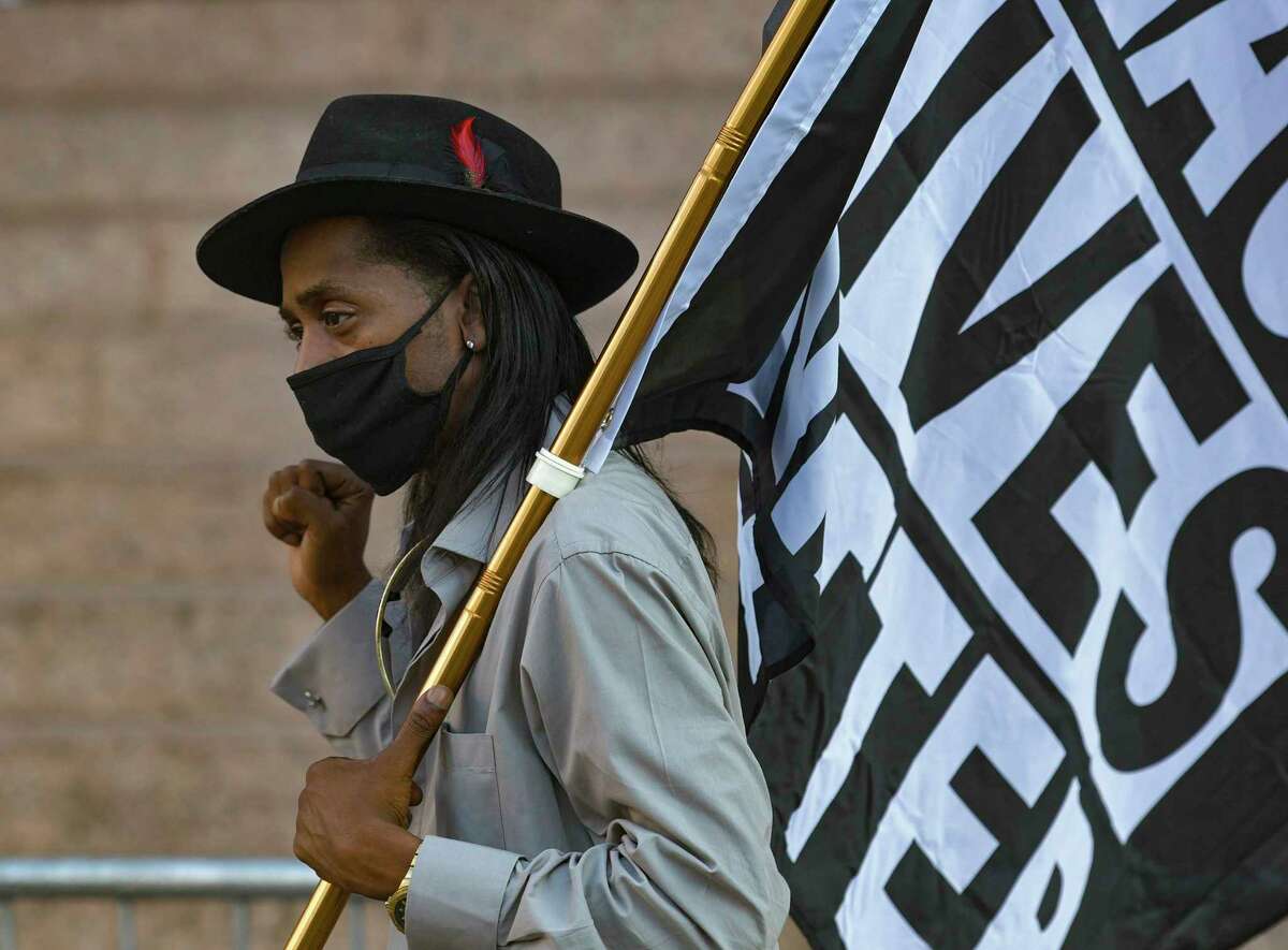 Pharaoh Clark carries a flag during an Ambitious Young Activists rally in downtown San Antonio on Friday, Sept. 25, 2020. The rally was held because a grand jury in Kentucky this week did not indict police officers who shot and killed Breonna Taylor, a Black woman, six times in March.