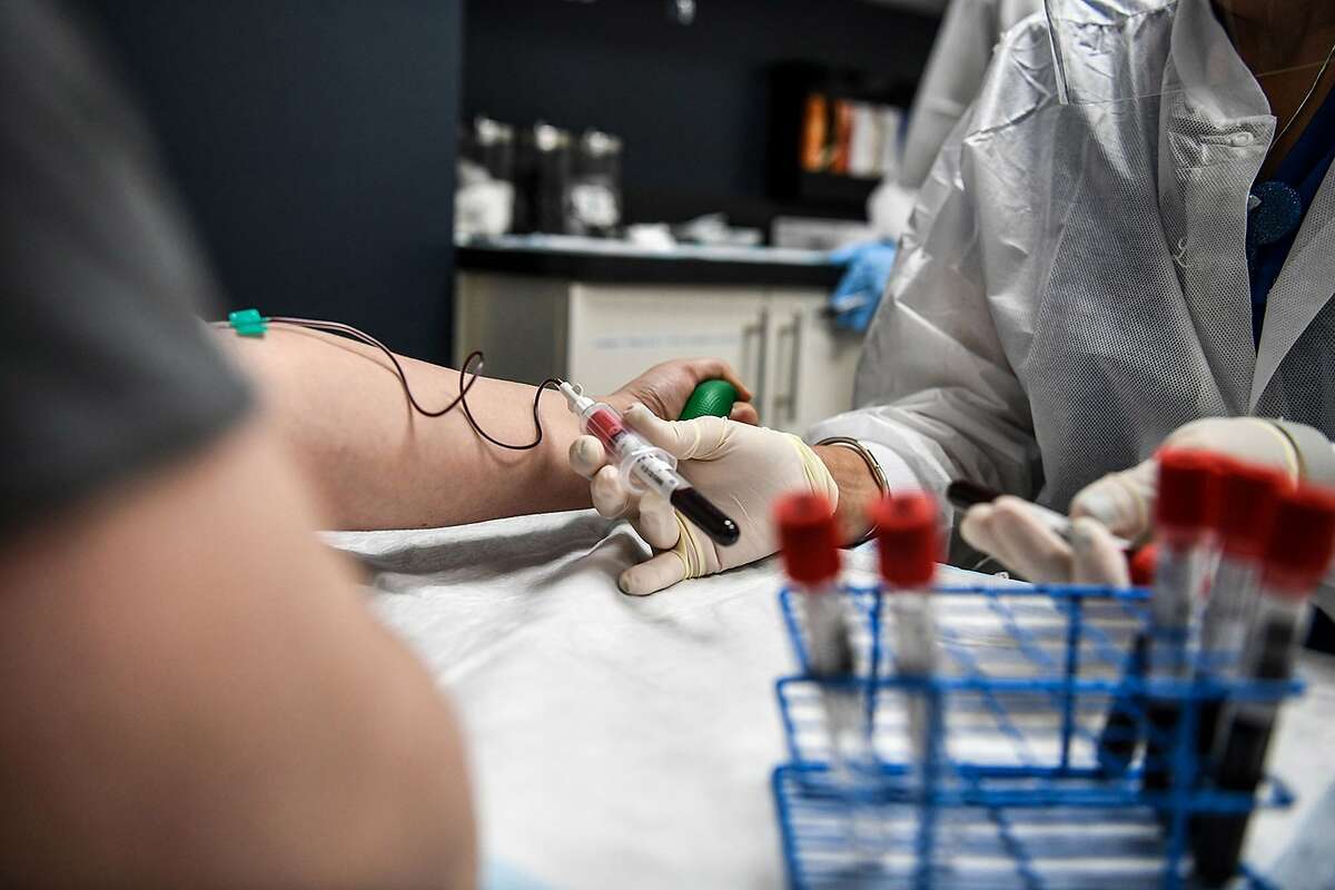 In this file photo, Laymis Alvarez takes blood samples from Heather Lieberman, 28, as she participates in a COVID-19 vaccine study at the Research Centers of America (RCA) in Hollywood, FL, on August 13, 2020. Here are the COVID -19 vaccines that have reached phase 3 as of Nov. 12, 2020, according to WHO.   Sinovac* — Beijing, China Vaccine platform: Inactivated | Number of doses: 2 *Trials halted in Brazil   Wuhan Institute of Biological Products/Sinopharm — Wuhan, China Vaccine platform: Inactivated | Number of doses: 2   University of Oxford/AstraZeneca — Cambrdige, Oxford, United Kingdom Vaccine platform: Inactivated | Number of doses: 2