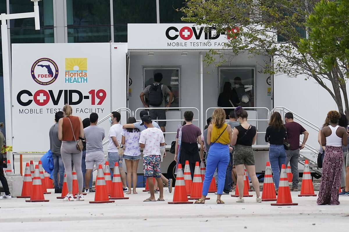People line up at a COVID-19 rapid test site, Saturday, Nov. 7, 2020 in Miami Beach, Fla. According to an AP analysis of data from John Hopkins University, the 7-day rolling average for daily new cases rose from 61,166 on Oct. 22 to 94,625 on Nov. 5. (AP Photo/Marta Lavandier)