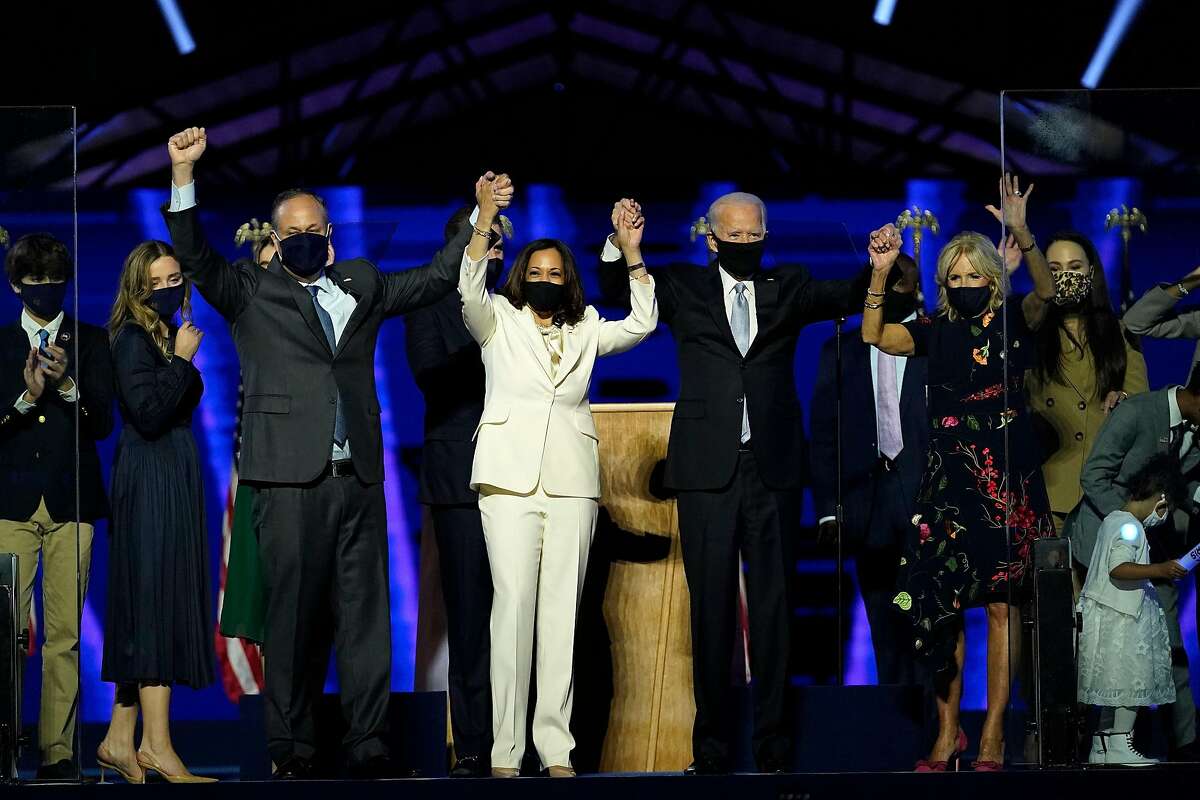 (From L) Husband of Vice President-elect Kamala Harris, Douglas Emhoff, Vice President-elect Kamala Harris, US President-elect Joe Biden and wife Jill Biden salute the crowd after delivering remarks in Wilmington, Delaware, on November 7, 2020, after being declared the winners of the presidential election.