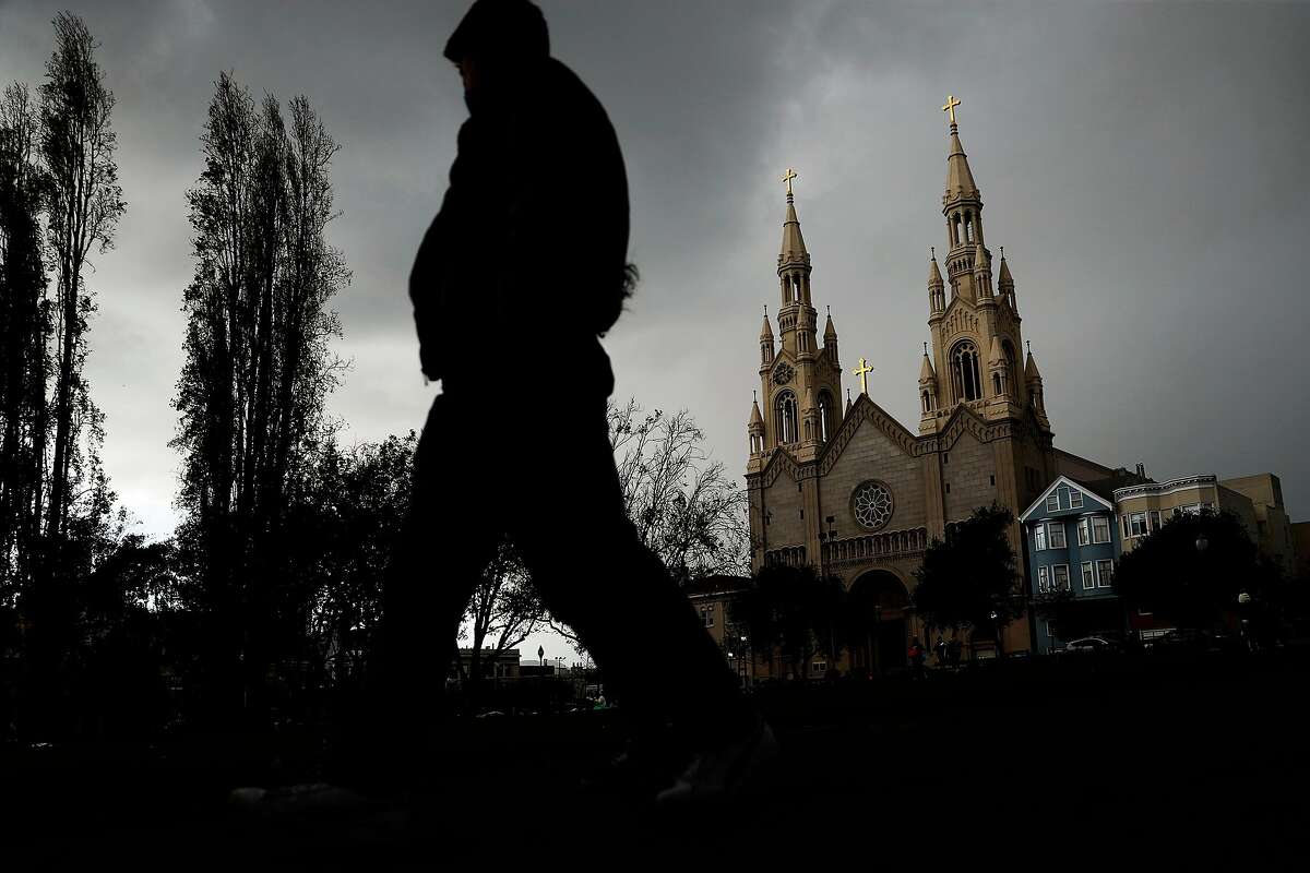 Rain clouds gather over Saints Peter and Paul Church near Washington Square Park in San Francisco on Sunday.