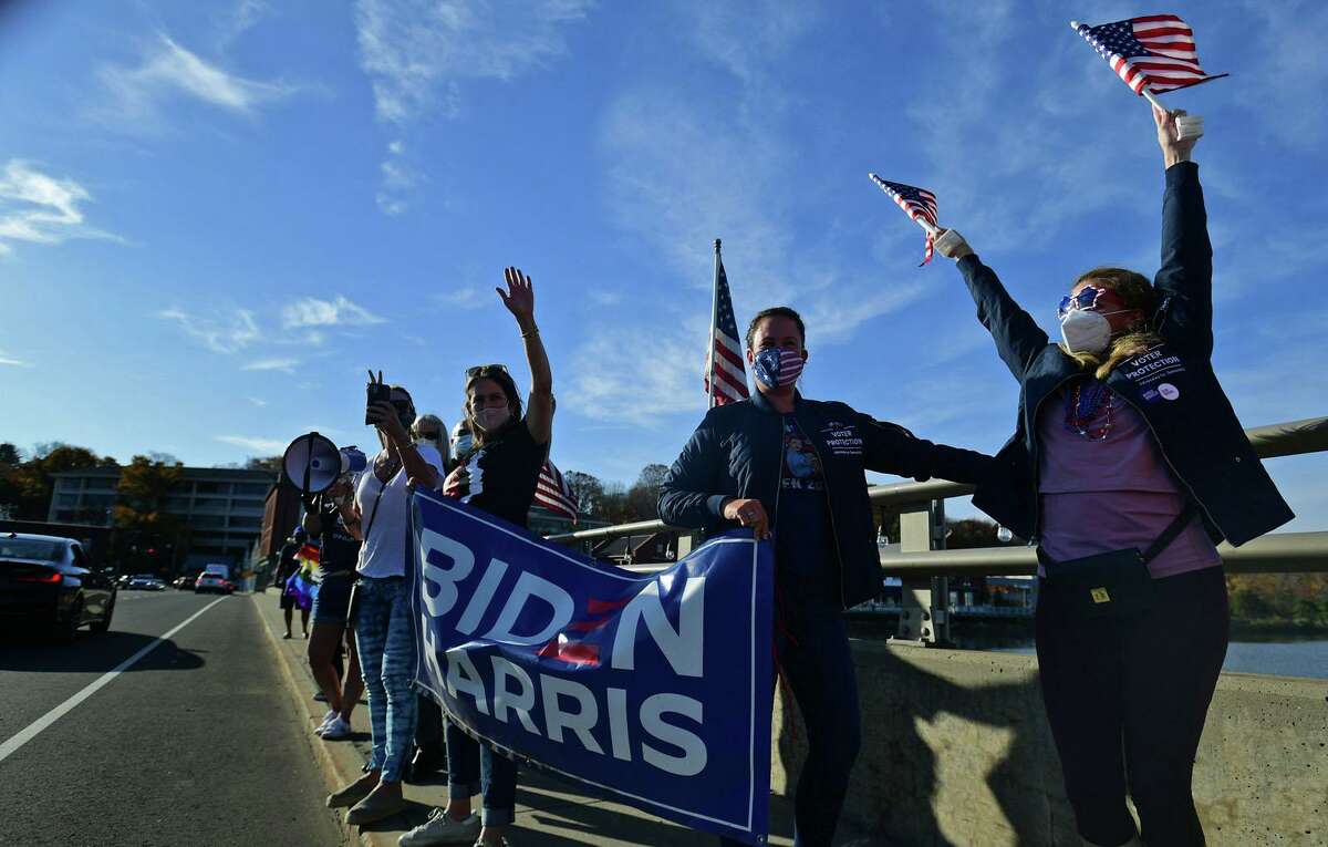Local residents gather at the Ruth Steinkraus bridge in downtown Westport to celebrate the Biden-Harris declaration of victory in the US presidential election Saturday, November 7, 2020, in Westport, Conn.