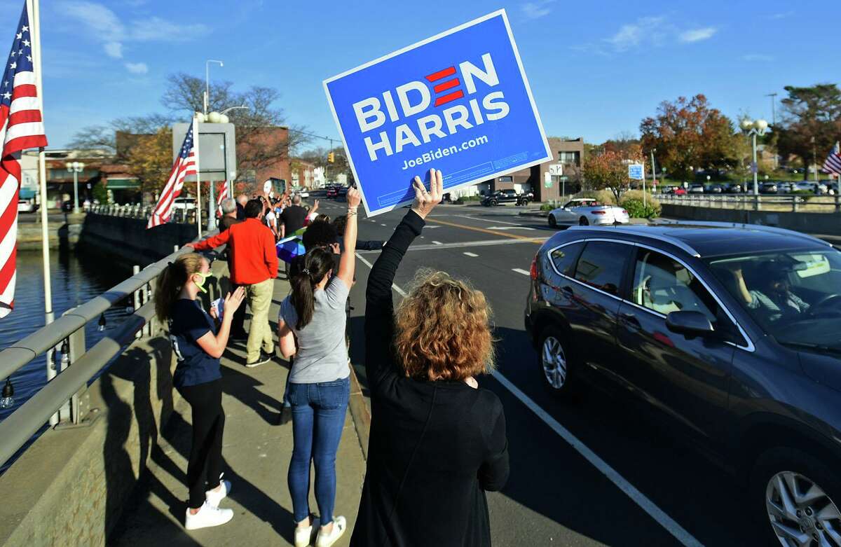 Local residents gather at the Ruth Steinkraus bridge in downtown Westport to celebrate the Biden-Harris declaration of victory in the US presidential election Saturday, November 7, 2020, in Westport, Conn.