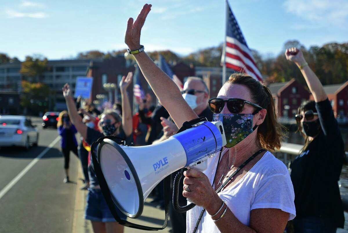 Local residents including Darcy Hicks gather at the Ruth Steinkraus bridge in downtown Westport to celebrate the Biden-Harris declaration of victory in the US presidential election Saturday, November 7, 2020, in Westport, Conn.
