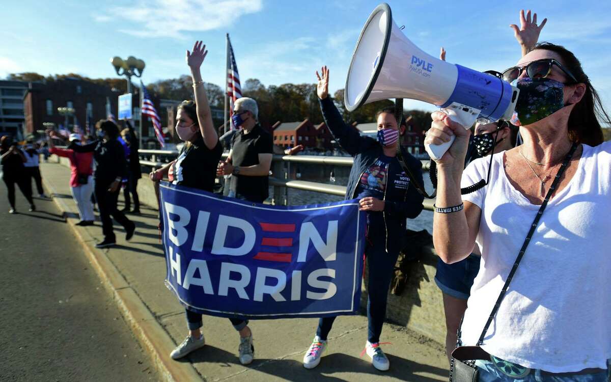 Local residents including Darcy Hicks gather at the Ruth Steinkraus bridge in downtown Westport to celebrate the Biden-Harris declaration of victory in the US presidential election Saturday, November 7, 2020, in Westport, Conn.