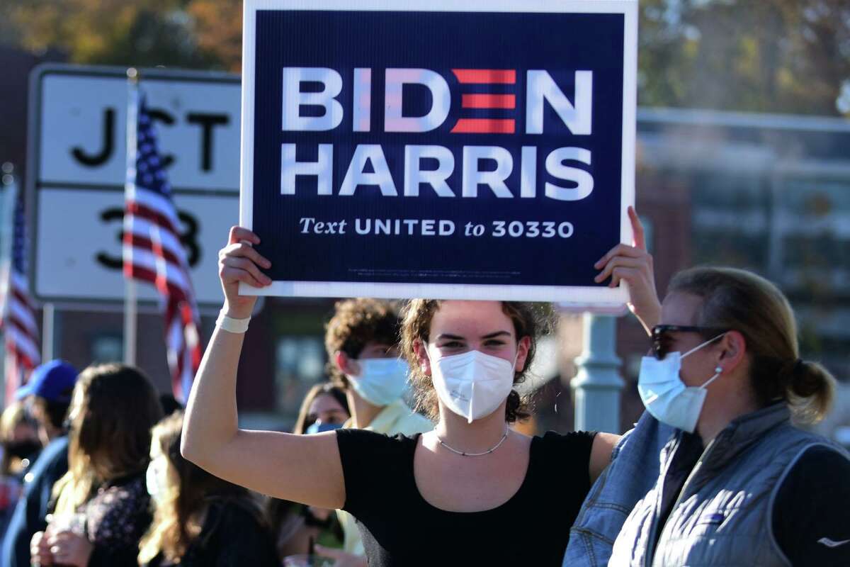 Local residents gather at the Ruth Steinkraus bridge in downtown Westport to celebrate the Biden-Harris declaration of victory in the US presidential election Saturday, November 7, 2020, in Westport, Conn.