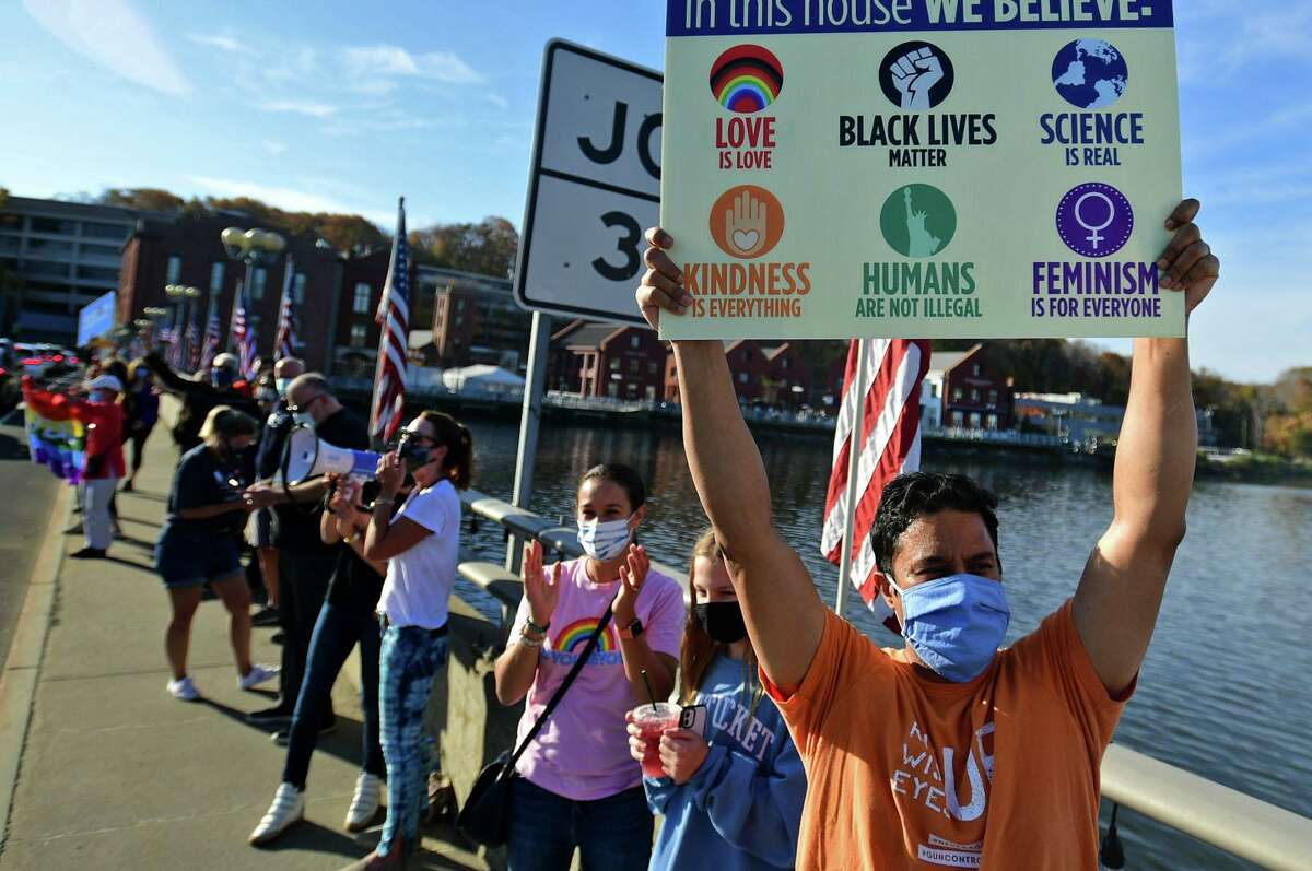 Local residents gather at the Ruth Steinkraus bridge in downtown Westport to celebrate the Biden-Harris declaration of victory in the US presidential election Saturday, November 7, 2020, in Westport, Conn.