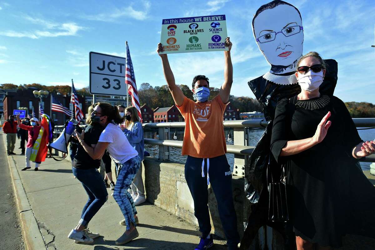 Local residents gather at the Ruth Steinkraus bridge in downtown Westport to celebrate the Biden-Harris declaration of victory in the US presidential election Saturday, November 7, 2020, in Westport, Conn.