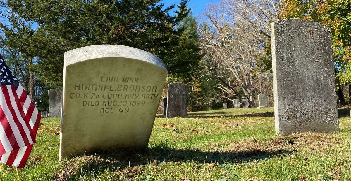 The gravestone of a Civil War soldier, whose stone was cleaned, contrasts with a non-cleaned gravestone.
