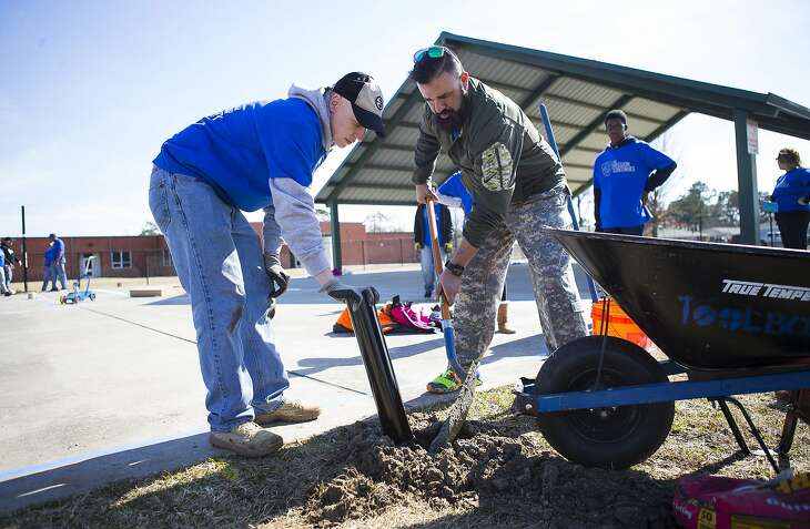 Raul Talavera (right), a U.S. Army combat veteran, assembles a basketball hoop at Roderick Paige Elementary School in the Kashmere Gardens community during a day of service with the organization The Mission Continues, Monday, Jan. 15, 2018, in Houston. The Mission Continues is a veteran-led, nationwide service organization that deployed around 200 volunteers at the elementary school on Monday. The organization has five platoons in the Houston area that perform service projects year round. ( Mark Mulligan / Houston Chronicle )