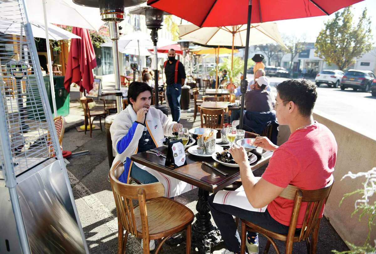 Greenwich's Charlie-Andre Jolly, left, and Brentwood, N.Y.'s Brian Torres dine outdoors at Bistro V in Greenwich in November. Outdoor dining on Greenwich Avenue is considered to have been a lifeline to local businesses over the summer and fall and now the Reimagine Greenwich committee is looking ahead to possible next steps.