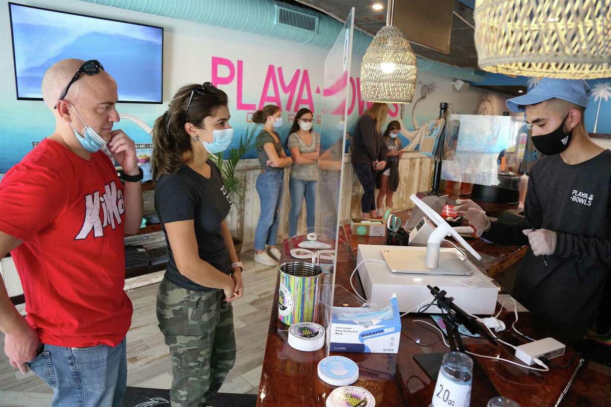 Happy customers Bill Jordan and Fabiana Riddles, both of Darien, place an order at the new Playa Bowls on the Boston Post Road on Sunday morning.