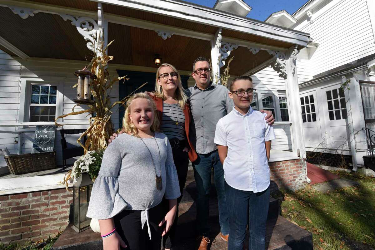 From left, Harmony, Sarah, John and Joshua Trop stand outside their historic home on Wednesday, Nov. 4, 2020 in Wynantskill, N.Y. Sarah and John Trop bought the home with a goal of restoring it. (Lori Van Buren/Times Union)