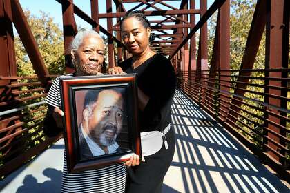 Catherine Lawson (left) carries a picture of her husband, Jerry Lawson, with their daughter Karen Lawson in San Jose. Jerry Lawson, a pioneer of Silicon Valley, died in 2011.