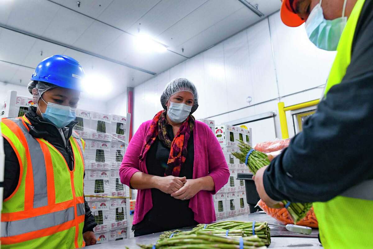 Zaira Escalera, left, and CEO Judy Clark watch as Lupe Torres, right, inspects asparagus at Fresh Texas.