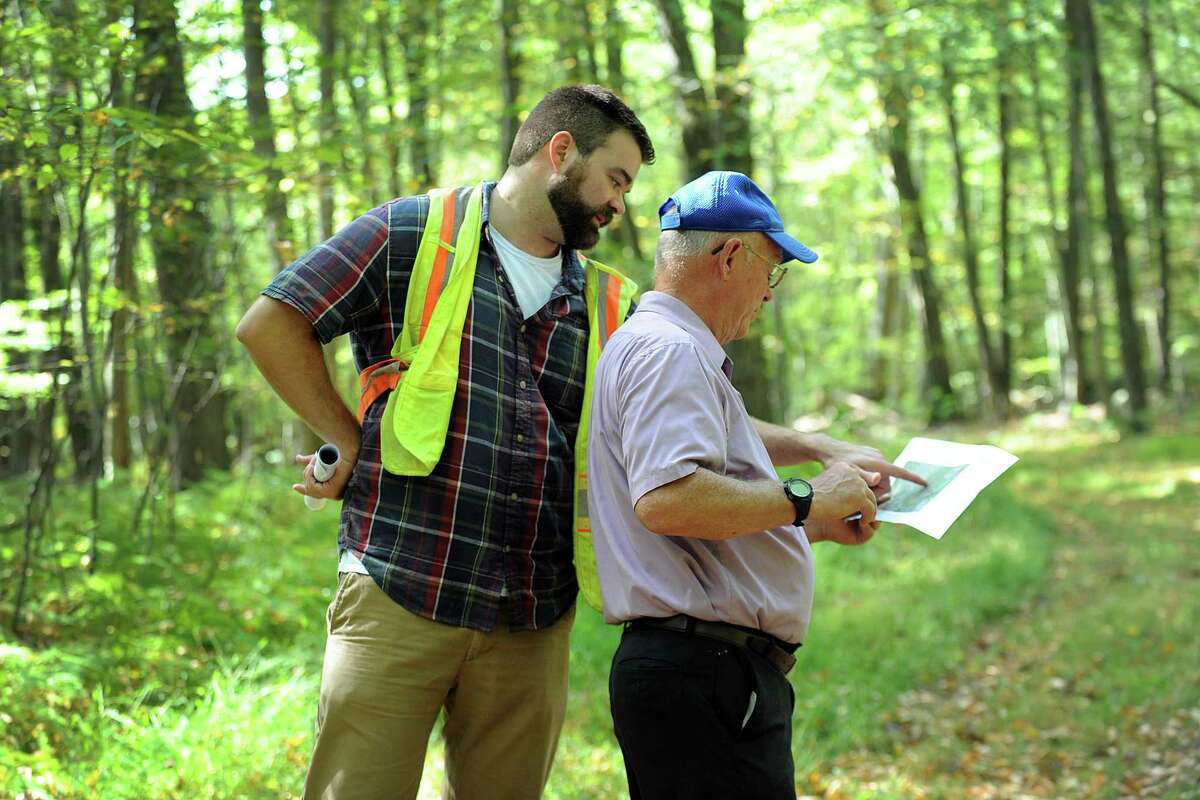 Paul Delmar, left, with Ameresco Candlewood Solar, and Frank Wargo, a town councilman, look at a map of the area where a solar panel array is proposed. The state Siting Council does a walking tour of the area where there is a proposal to build solar panels on Candlewood Mountain in New Milford, Tuesday, Sept. 26, 2017.