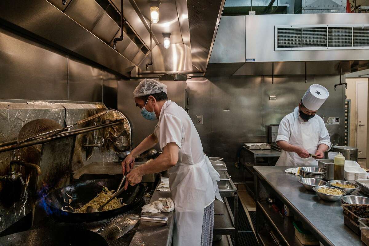 Line cook Jing Zhen Hu (left) and Chef Chao Hua Lei prepare dishes at Yank Sing. Entertainment Commissioner Steven Lee, who is an investor in the historic Sam Wo Chinatown restaurant, said thinks restaurants should be exempt from the natural gas ban, saying, “No way in hell you are going to put a wok on an electric stove.”
