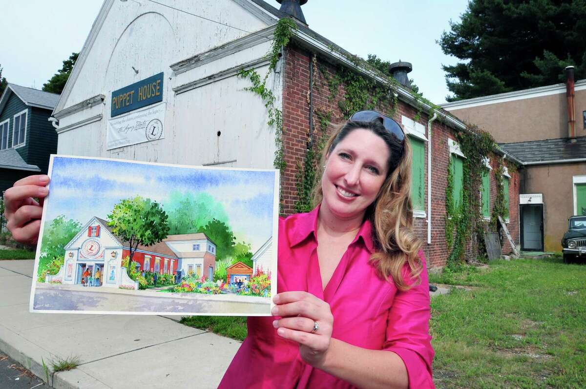 Keely Baisden Knudsen, artistic director of the Legacy Theatre, holds an artist's rendering of plans for the former Puppet House in 2012.