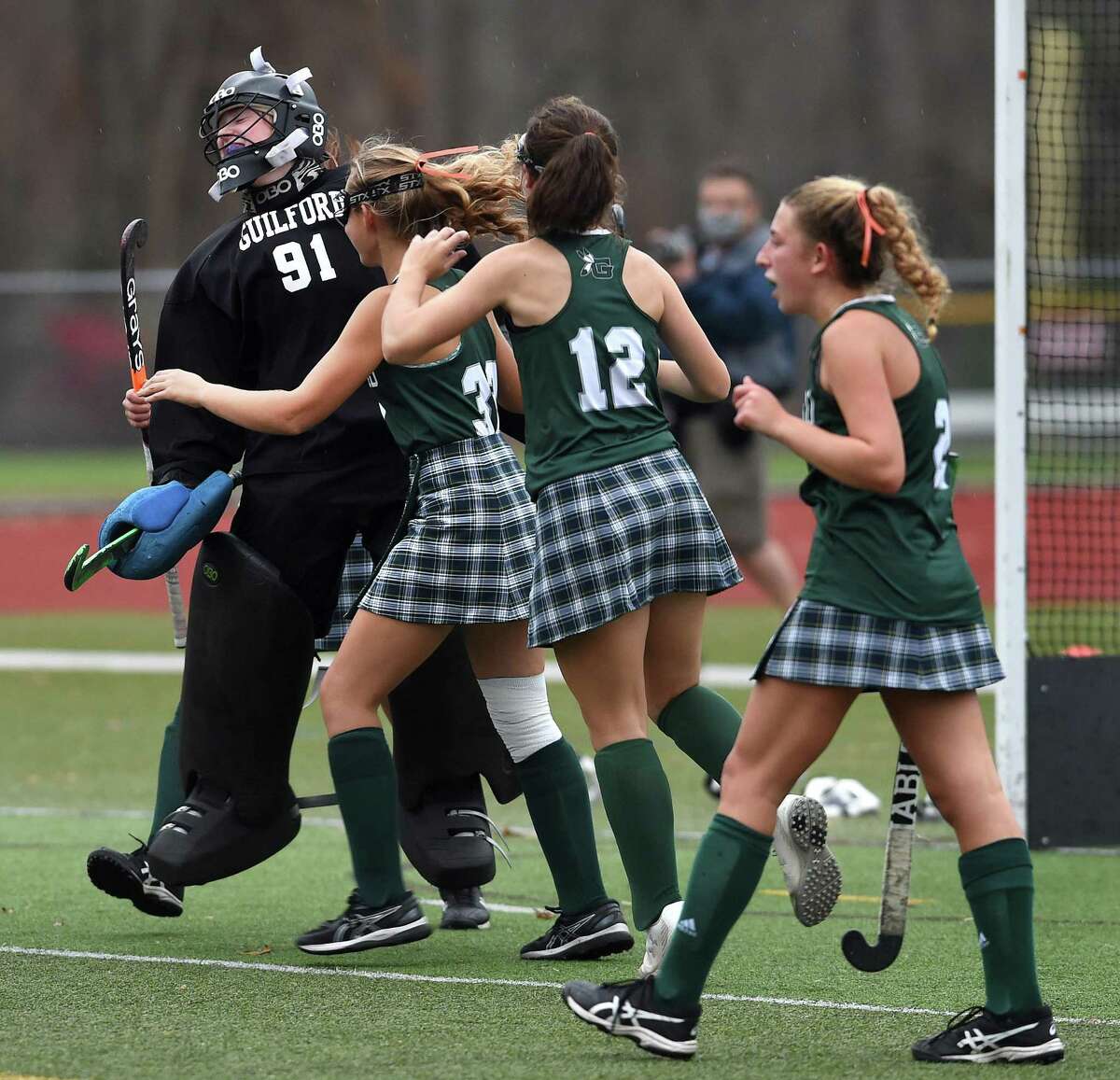 Guilford goalkeeper Eve Young, left, celebrates with teammates after its 5-1 win over Cheshire in the SCC Division A field hockey championship at Cheshire High on Wednesday.