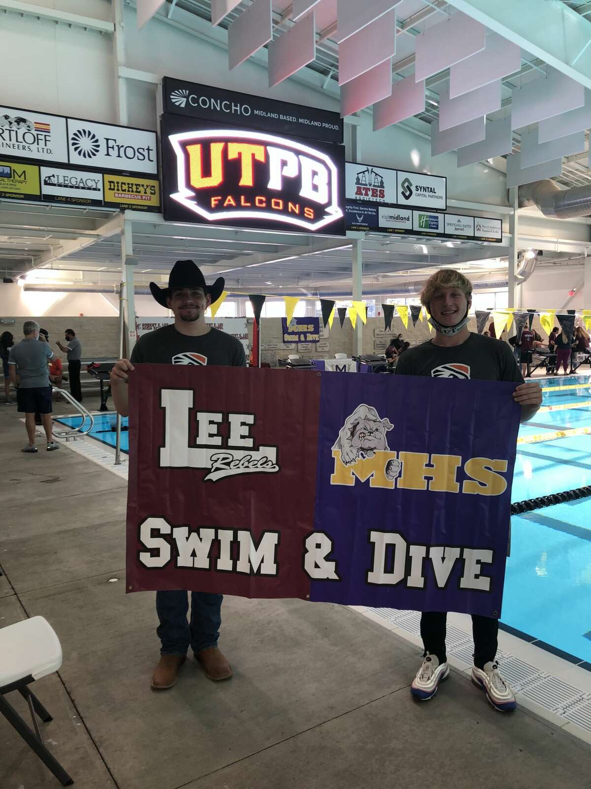 Lee's Erik Eikenbary, left, and Midland High's Legend Jankowski hold up a banner after both signed to swim for UT-Permian Basin during a ceremony, Nov. 11 at COM Aquatics.