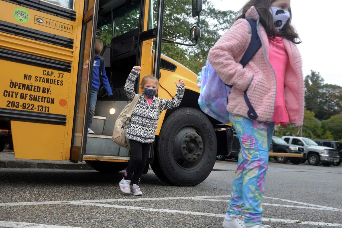 Students disembark from a school bus as the arrive at Sunnyside Elementary School, in Shelton, Conn. Oct. 13, 2020.