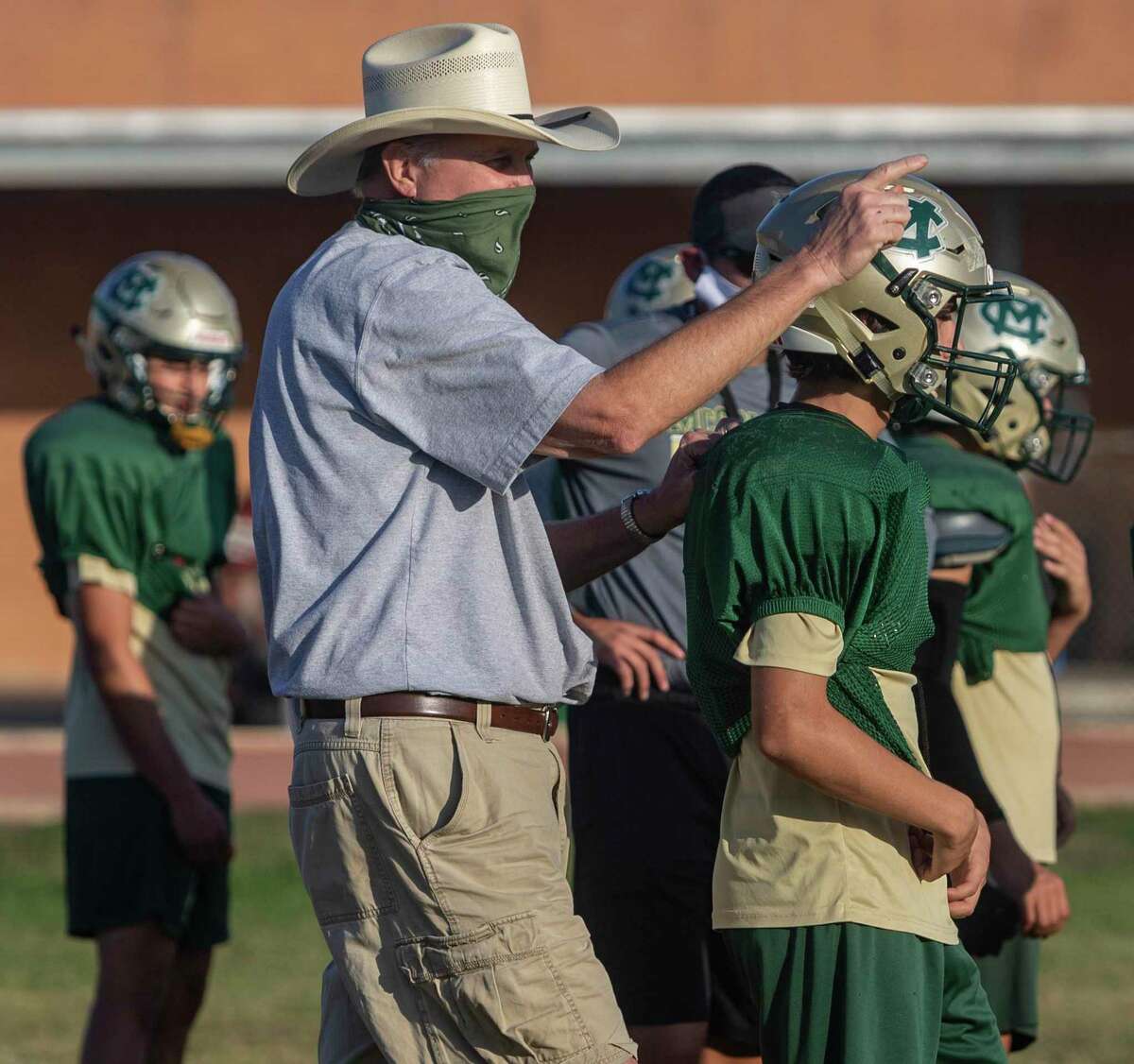 McCollum High School coach Carl Klann runs through drills Wednesday, Nov. 11, 2020 with the team as they prepare for their first game after having to forfeit three games due to positive COVID-19 coronavirus tests.