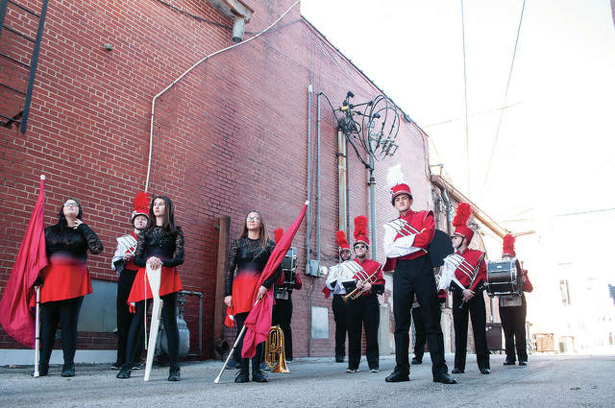 Photographer Karen Anderson directs the Jacksonville High School marching band on Thursday while setting up for senior photos. The photo shoot took place in an alley off Main Street.
