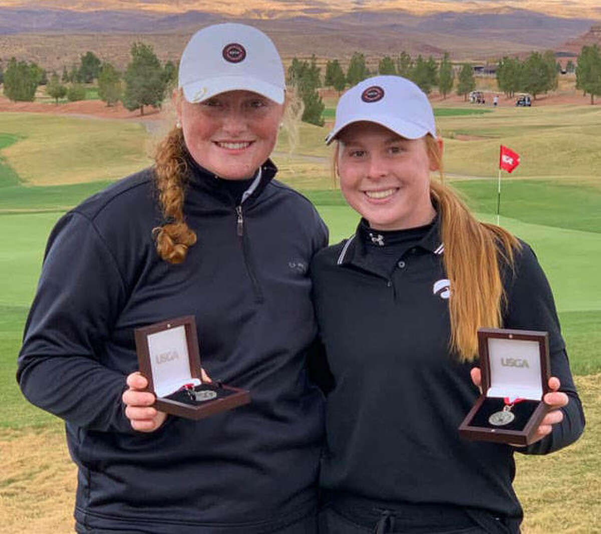 Marquette Catholic junior Gracie Piar (left) and Edwardsville junior Riley Lewis show off their championship medals from the 2021 U.S. Women’s Amateur Four-Ball Qualifying golf tourney Monday at SunRiver Golf Club in St. George, Utah.
