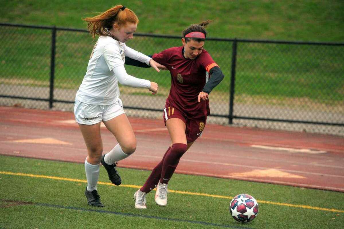St. Joseph’s Maddie Fried,competes with Trumbull’s Elizabeth Foley during high school soccer action at St. Joseph.