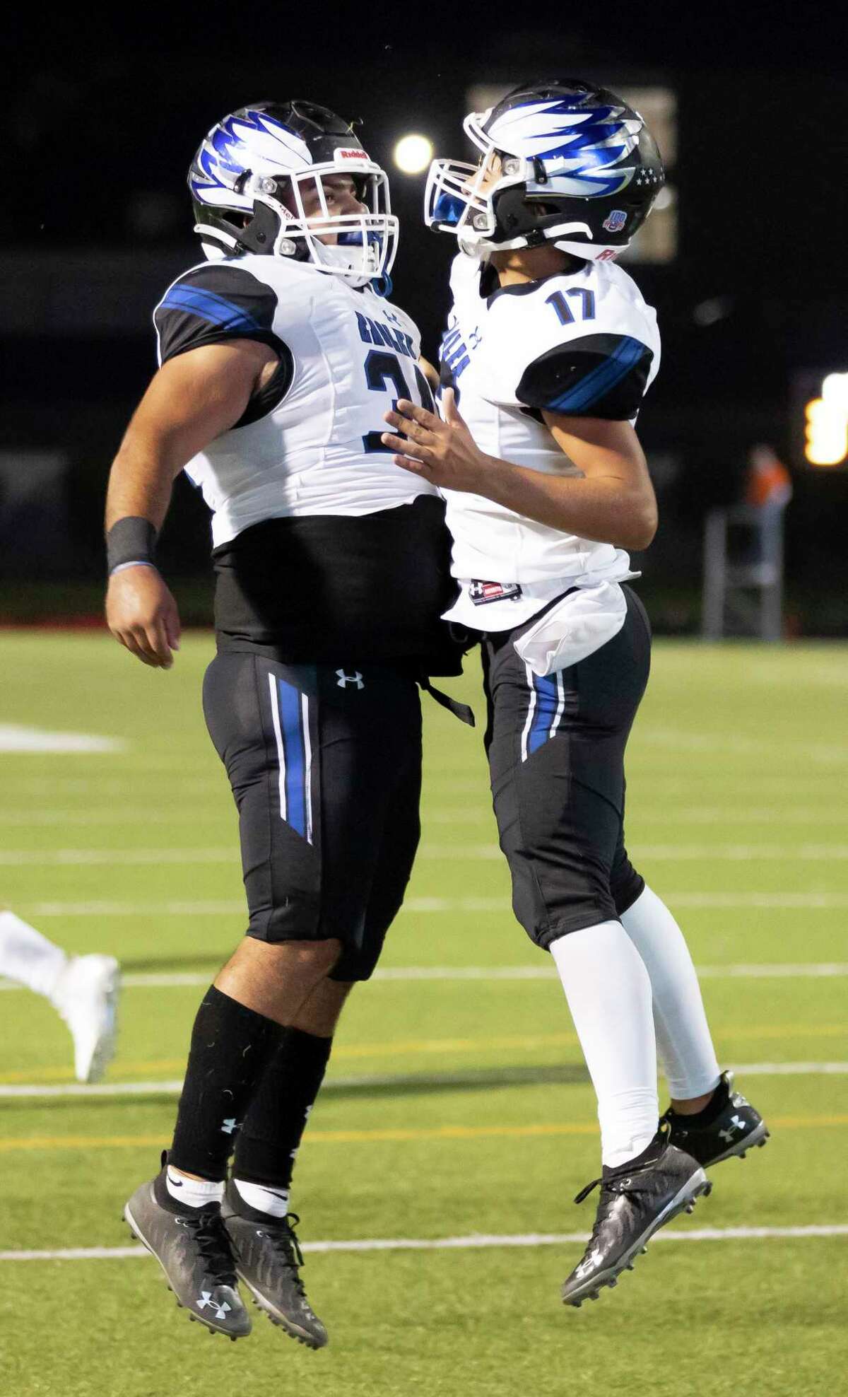 New Caney running back Casen Rios (17) and fullback Tayte Baker (34) celebrate after they score a touchdown during the third quarter of a District 8-5A (Div. I) football game against Caney Creek at Moorhead Stadium in Conroe.