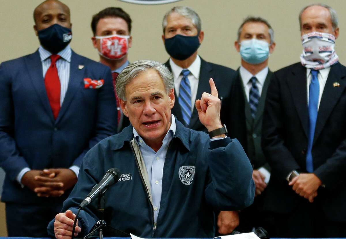 Gov. Greg Abbott, center, talks to reporters during a press conference inside the Houston Police Officer's Union Headquarters, where he signed a "back the blue" pledge Wednesday, Oct. 28, 2020, in Houston.