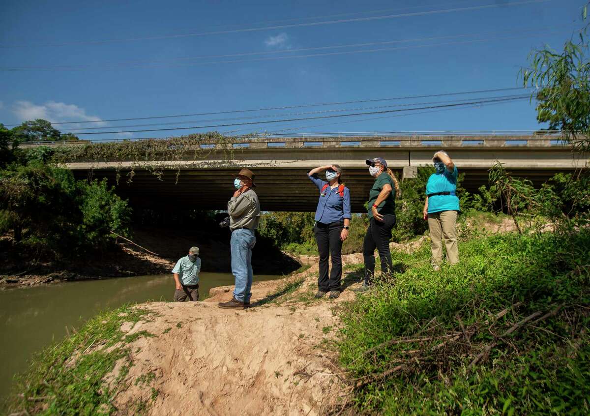 (LtoR) John Bartos, with the Bayou Preservation Association, Bruce Bodson with the Houston Canoe Club, Sarah Bernhardt, president and CEO of the Bayou Preservation Association, Carolyn White, conservation director at the Memorial Park Conservancy, and Natalie Wiest, with the Houston Canoe Club, look at a canoe launch point on Buffalo Bayou where it passes under Woodway Drive just west of the 610 Loop on Friday, Nov. 6, 2020, in Houston. White describes this part of the bayou as a good example of an unstable stream system with highly eroded banks causing major land-loss and sediment loading that is pushing downstream into Buffalo Bayou Park.