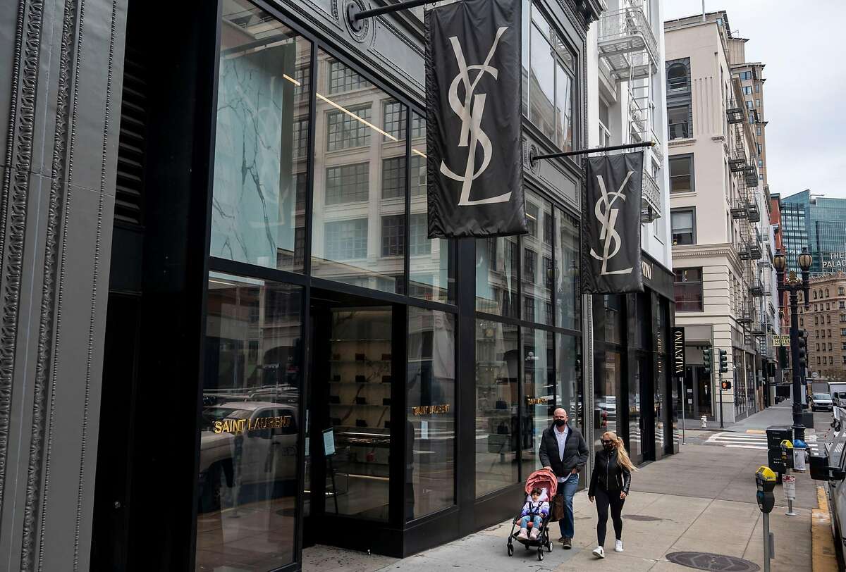 People walk past the the Yves Sant Laurent on Geary Street in San Francisc on Friday. The city’s unemployment rate fell from 8.4% in September to 6.9% in October.