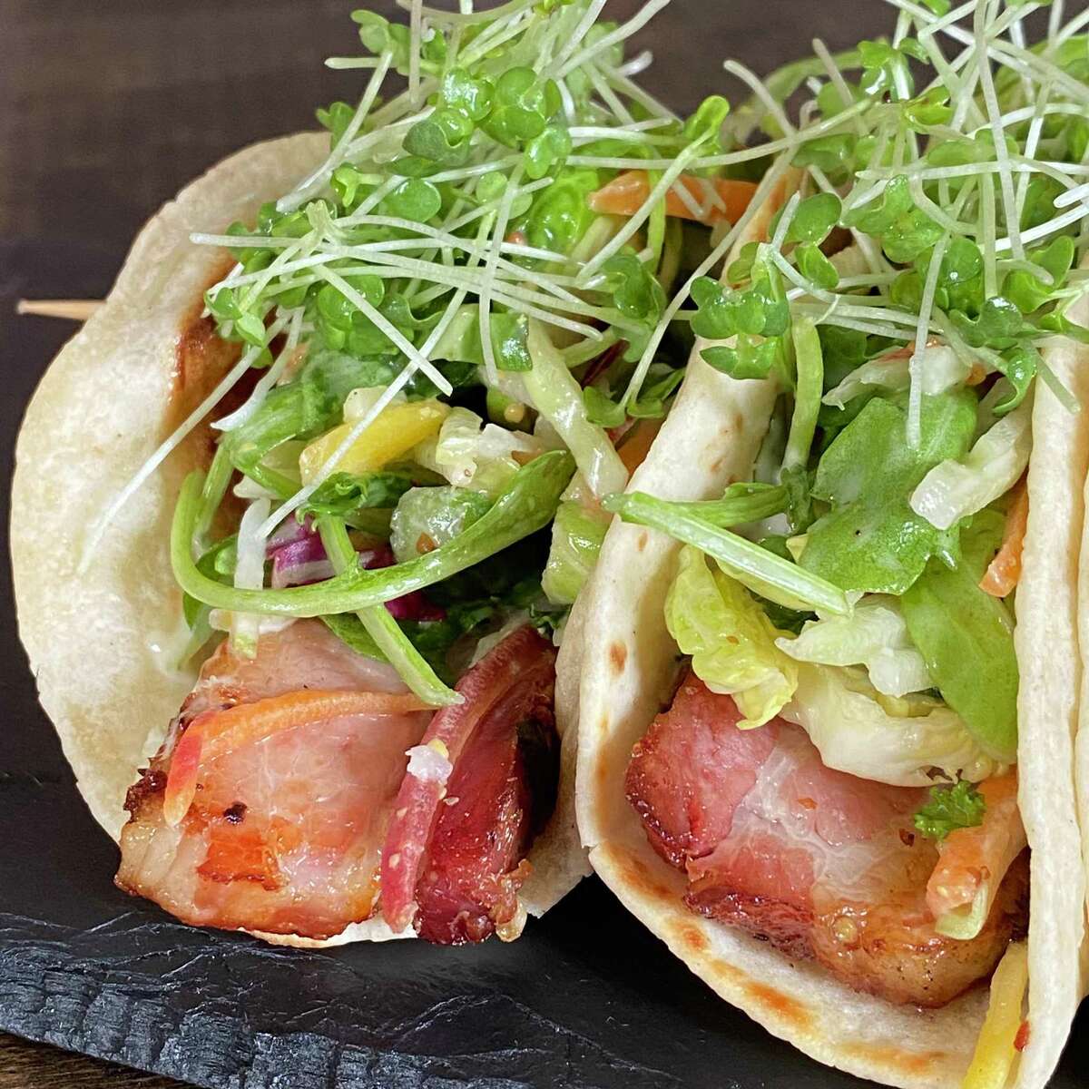Braised Bacon Tacos are one of the small and share plate items from 1754 House’s menu.
