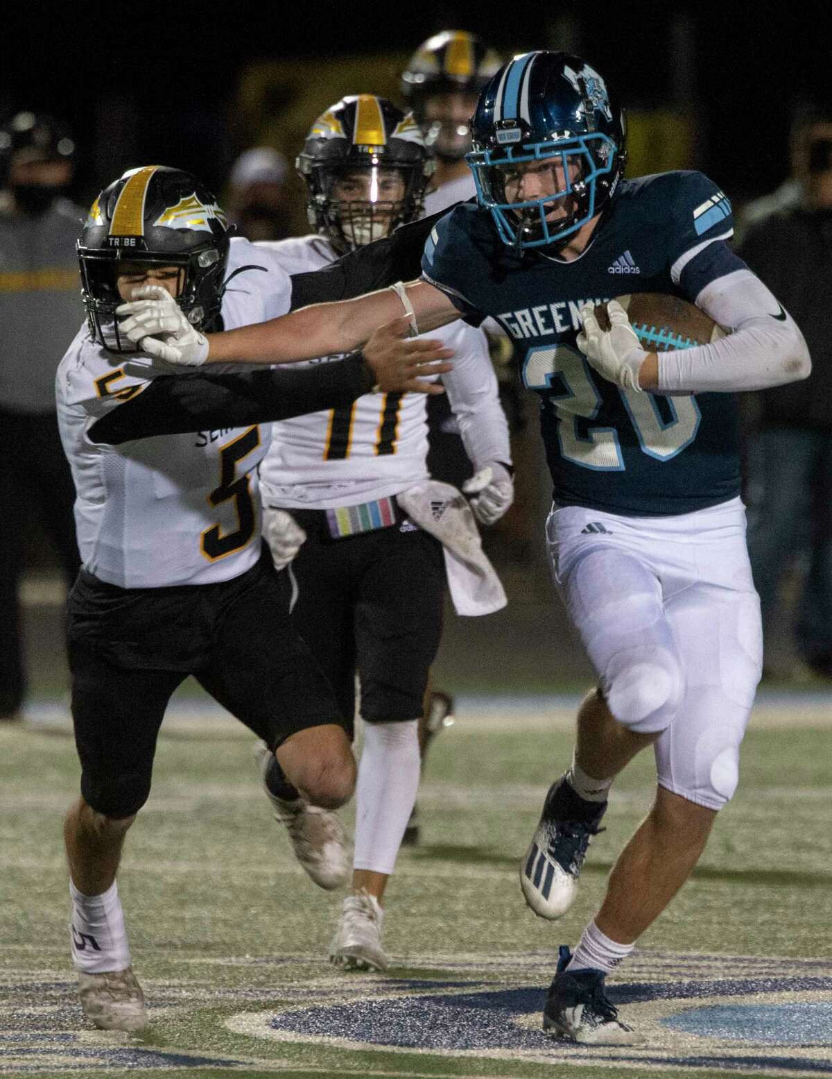 Greenwood's Christian Cook looks for more yards with a stiff-arm to Seminole's River Powers 11/13/2020 at J.M. King Memorial Stadium. Tim Fischer/Reporter-Telegram