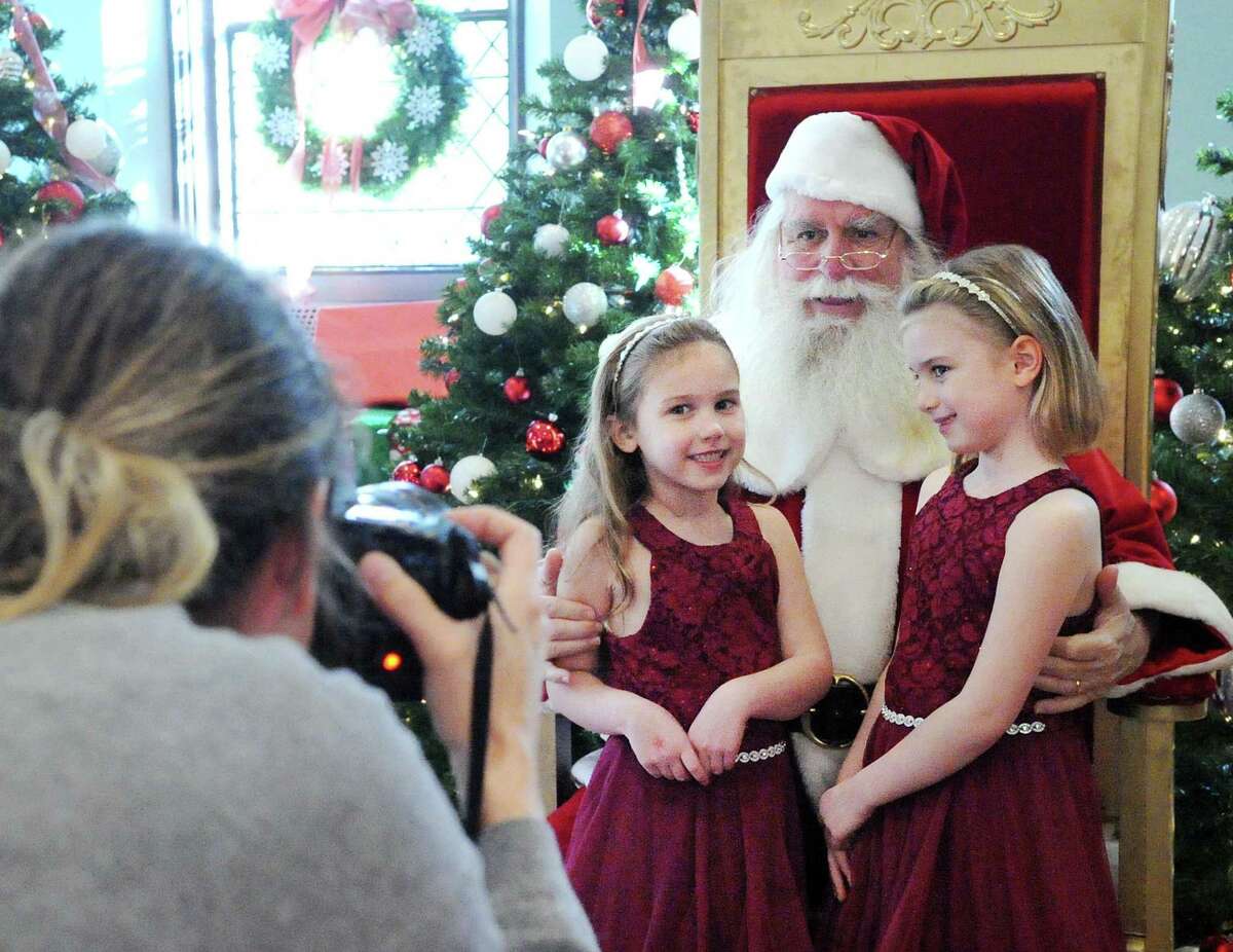 Greenwich residents Stella Smith, 6, left, and her sister, Lily Smith 7, wore matching maroon dresses as they had their photo taken with Santa during the Junior League of Greenwich annual Enchanted Forest event at Christ Church in 2017. The Enchanted Forest will be moving online due to the pandemic. People can begin reserving special events for their families now.
